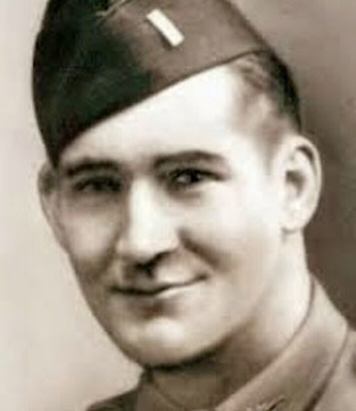 A young soldier in his garrison cap smiles at the camera.