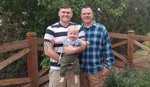 Staff Sgt. Hayden Murray, second-generation 100th Missile Defense Brigade crew member, left, says the values he learned as an Army brat guide him in his military career. His father, retired Chief Warrant Officer III Kale Murray, right, who also served as a crew member with the 100th Missile Defense Brigade, currently serves as the government lead for the Sensor Manager Qualification Course for the U.S. Army Space and Missile Defense Command. Murray holds his oldest son, Lane, who will be learning his own Army brat lessons. (Courtesy photo)