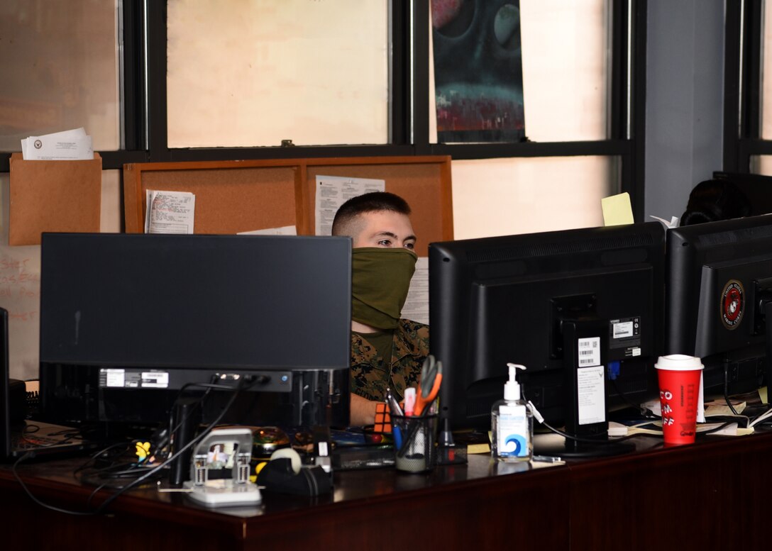 U.S. Marine Corps Corporal Jonathan Gloden, Marine Corps Detachment administrative clerk, types on his computer while wearing a mask inside the MCD Personnel Administrative Office on Goodfellow Air Force Base, Texas, April 22, 2020. Many individuals worked from home during the public health emergency, but Gloden was an essential personnel and worked as usual amidst the pandemic. (U.S. Air Force photo by Airman 1st Class Abbey Rieves)