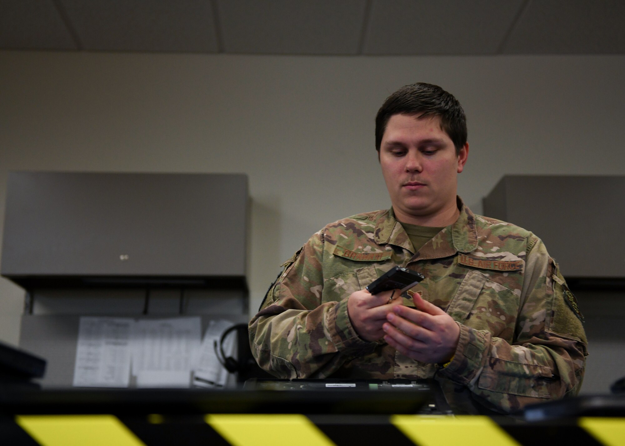 An Airman looks at a computer part.