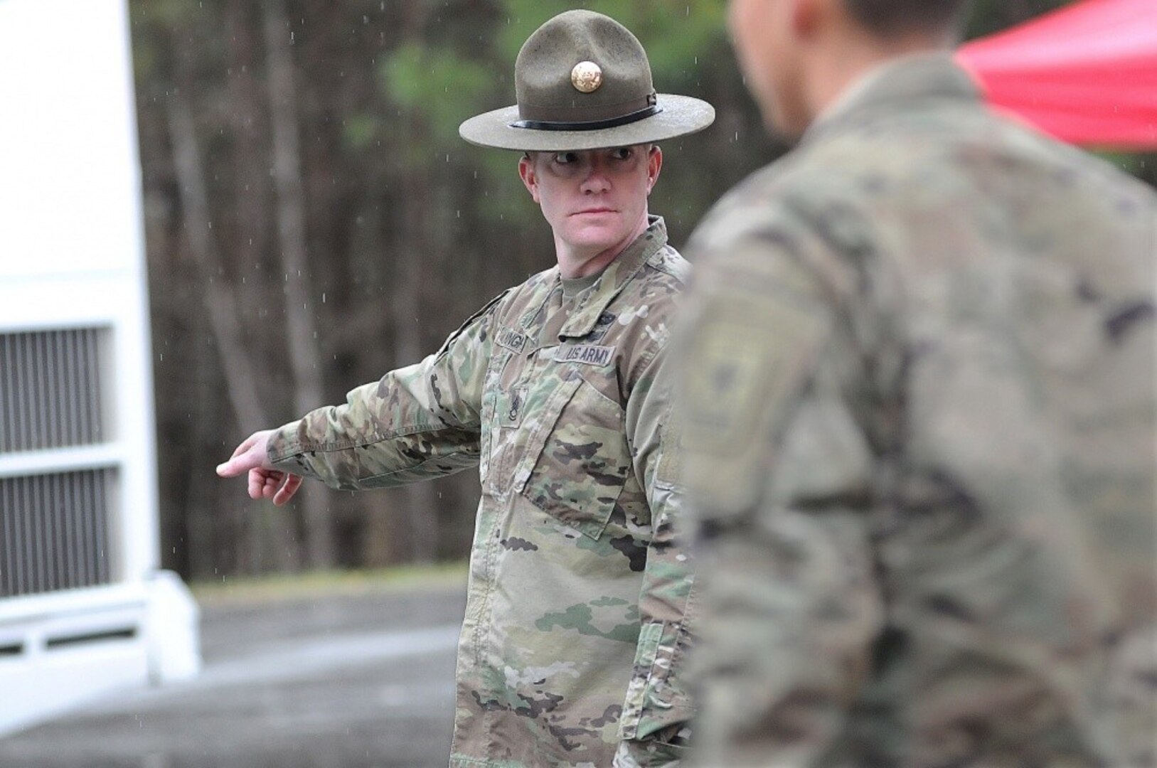 Sgt. 1st Class Jessy Kingrey directs troops to unload duffel bags after they arrived here from basic combat training at Fort Jackson, South Carolina.