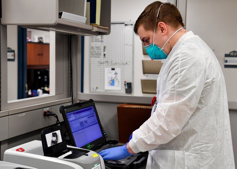 A medical technician tests a COVID-19 sample.