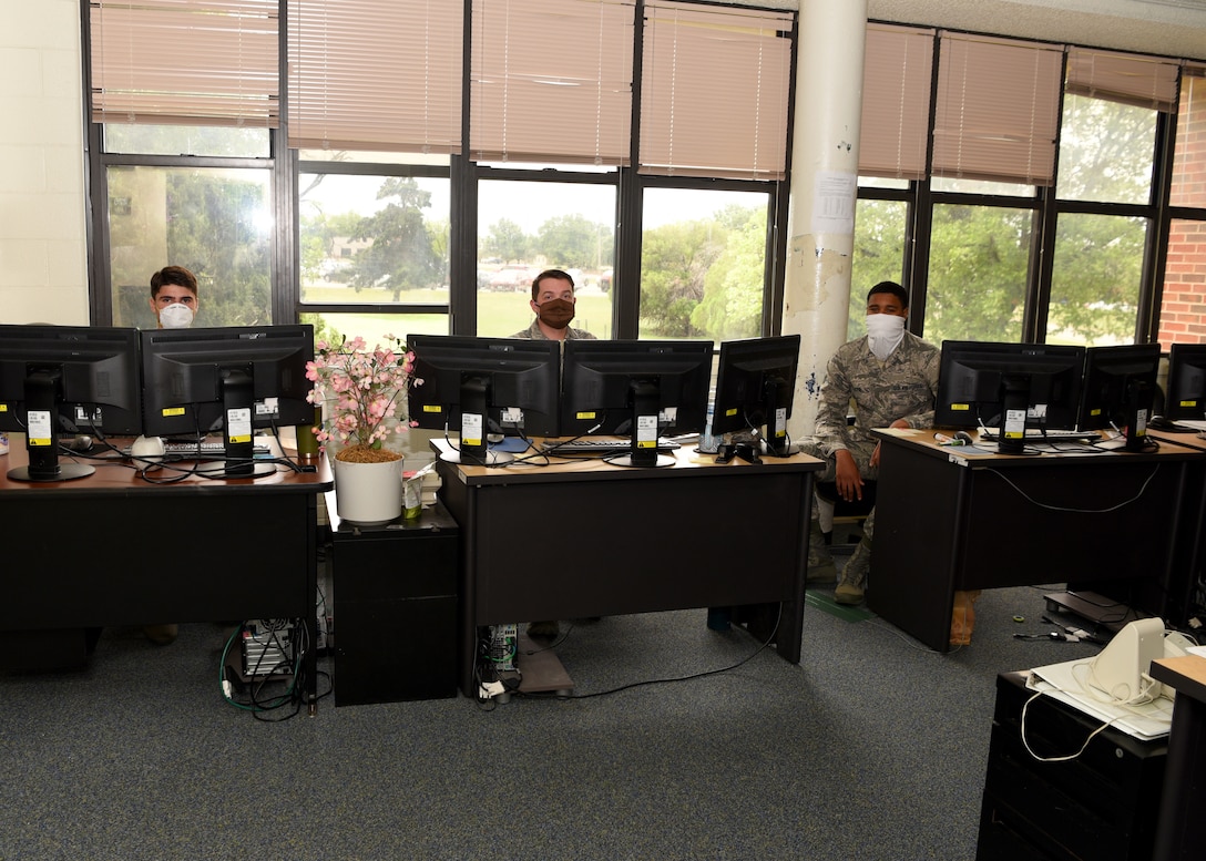 U.S. Air Force client system technicians from the 17 Communications Squadron review work request tickets for computers around base while maintaining a social distance in the COMM building on Goodfellow Air Force Base, Texas, April 22, 2020. The Airmen fixed and solved computer issues on-site and in the field, which instilinged mission readiness while adhering to the Center of Disease Control guidelines during the COVID-19 pandemic. (U.S. Air Force photo by Airman 1st Class Abbey Rieves)