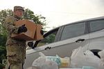 Louisiana National Guard Spc. Nicholas Campbell, with the 1022nd Engineer Company, 225th Engineer Brigade, carries boxes of food to put in an elderly person’s car in Colfax, Louisiana, April 22, 2020.