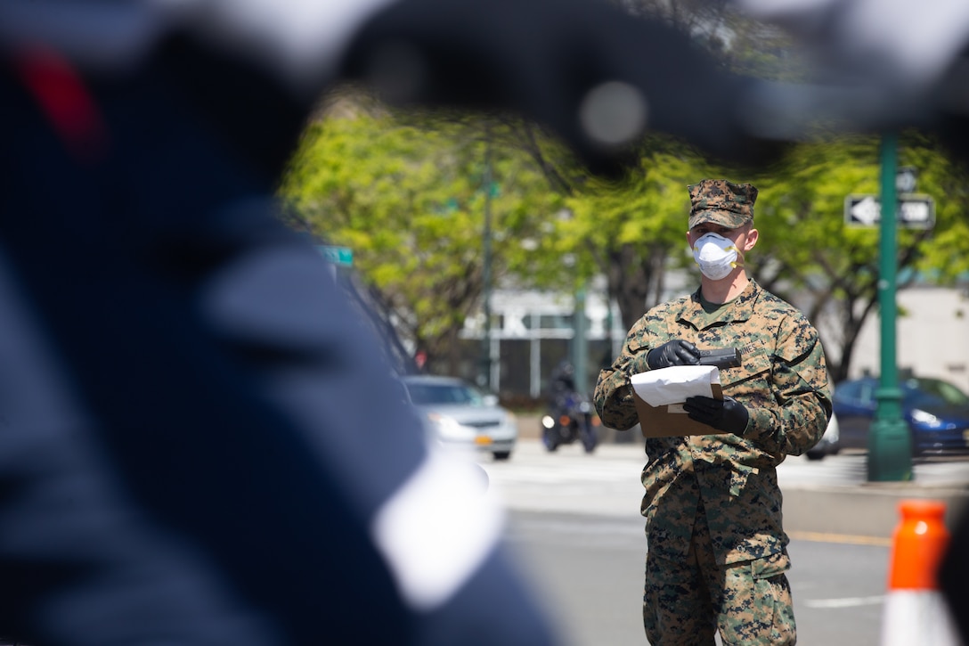 A Marine observes pedestrians¬ while providing security for the USNS Comfort during COVID-19 relief efforts in New York City, April 19.