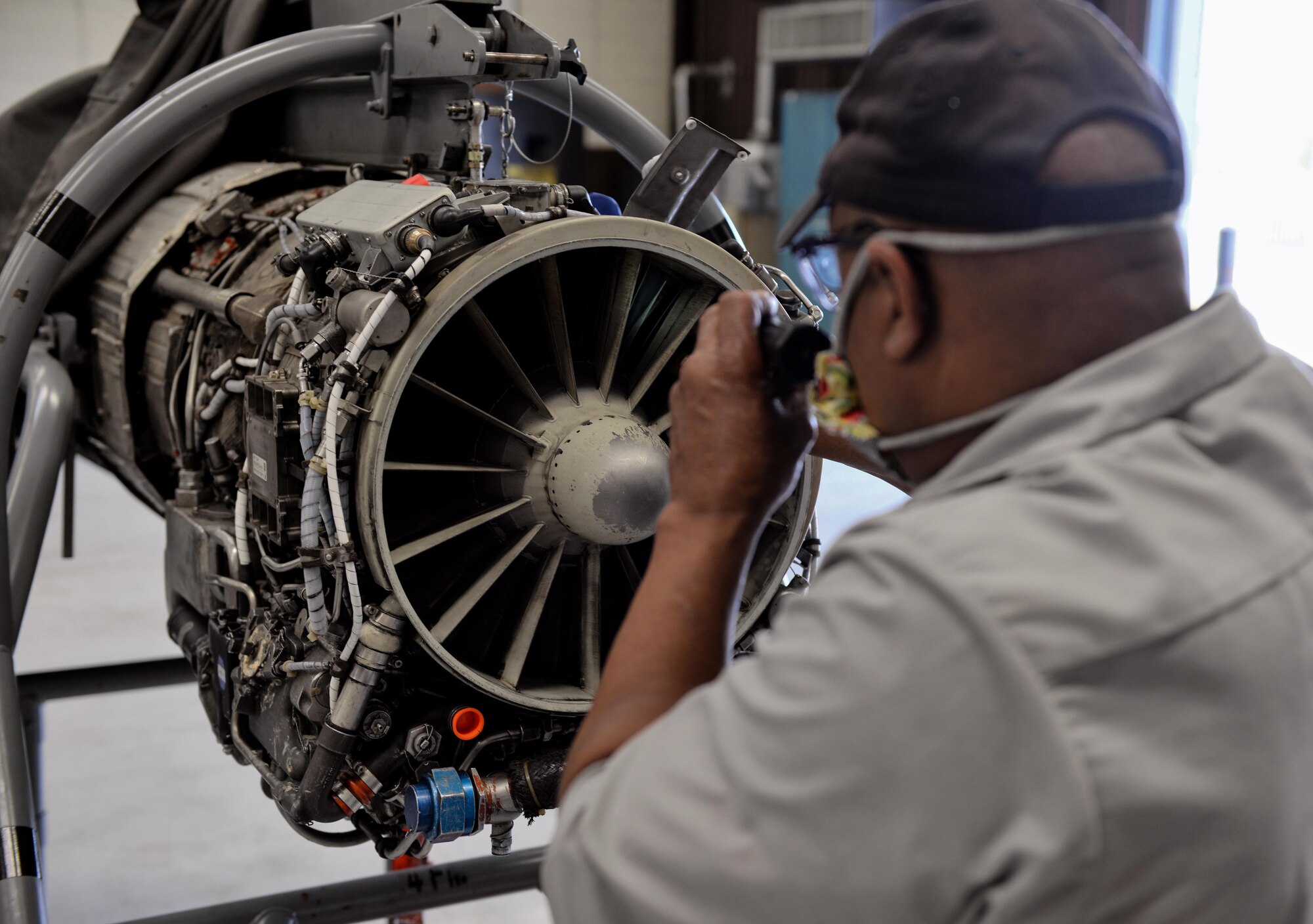Willy Latham, M1 Support Services propulsion mechanic, inspects a General Electric J85-GE-5 turbojet engine, designed for a T-38 Talon April 17, 2020, at Columbus Air Force Base, Miss. The T-38 is a twin-engine, high-altitude, supersonic jet trainer used in a variety of roles because of its design, economy of operations, ease of maintenance, high performance and exceptional safety record. (U.S. Air Force photo by Airman 1st Class Davis Donaldson)