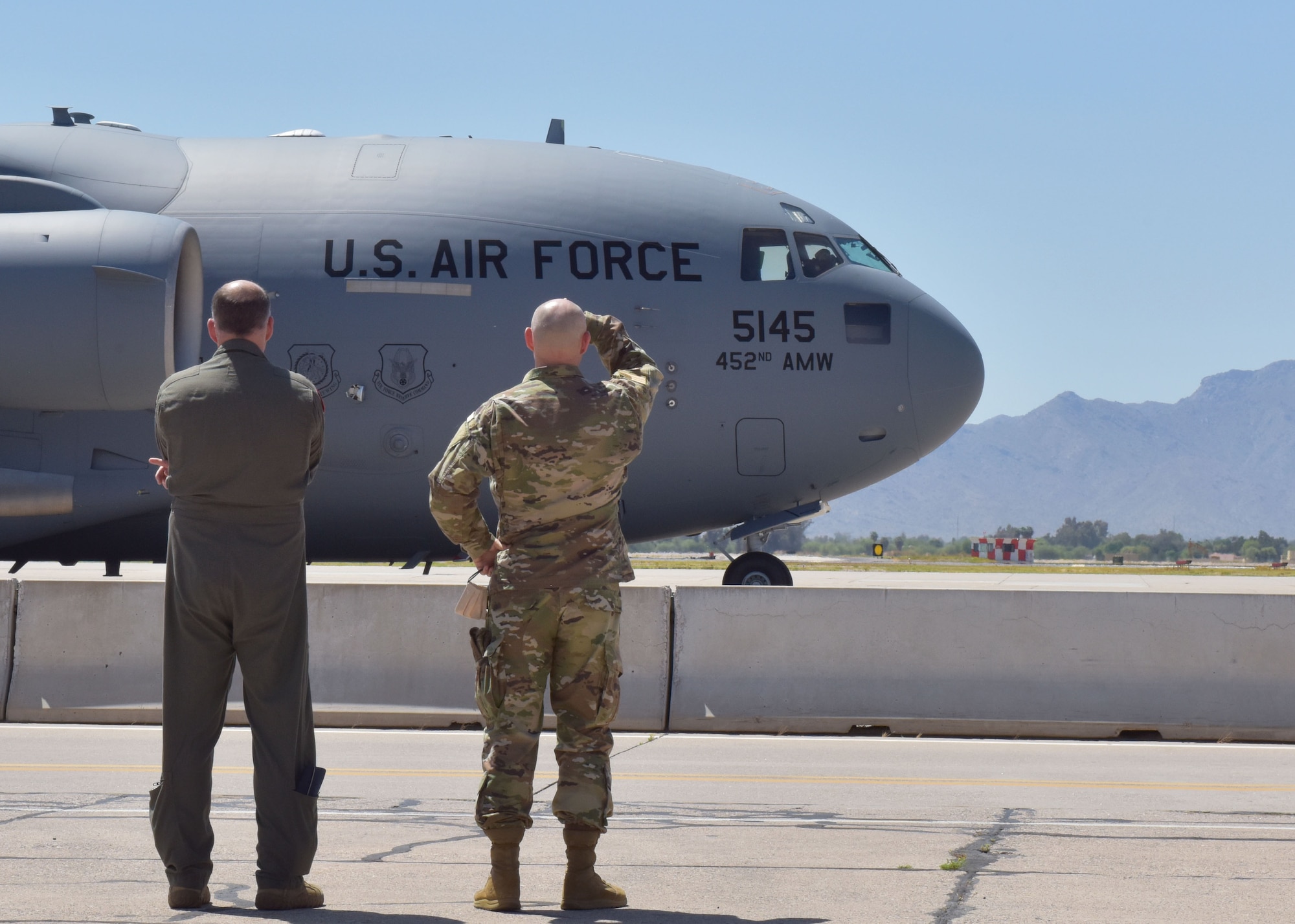 Col. Sean Rassas (left) and Col. James Greenwald (right), 944th Fighter Wing vice-commander and commander, observe the departure of their Reserve Citizen Airmen April 22 at Luke Air Force Base, Ariz. Over a dozen 944th Fighter Wing medics were tasked to aid in Coronavirus response in and around New York City. (U.S. Air Force photo by Tech. Sgt. Louis Vega Jr.)
