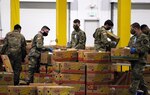 Washington Army National Guard members pack boxes of food at the Food Lifeline temporary site in Seattle April 21, 2020. Members of the Washington Air and Army National Guard are supporting food banks around the state during the COVID-19 pandemic response.