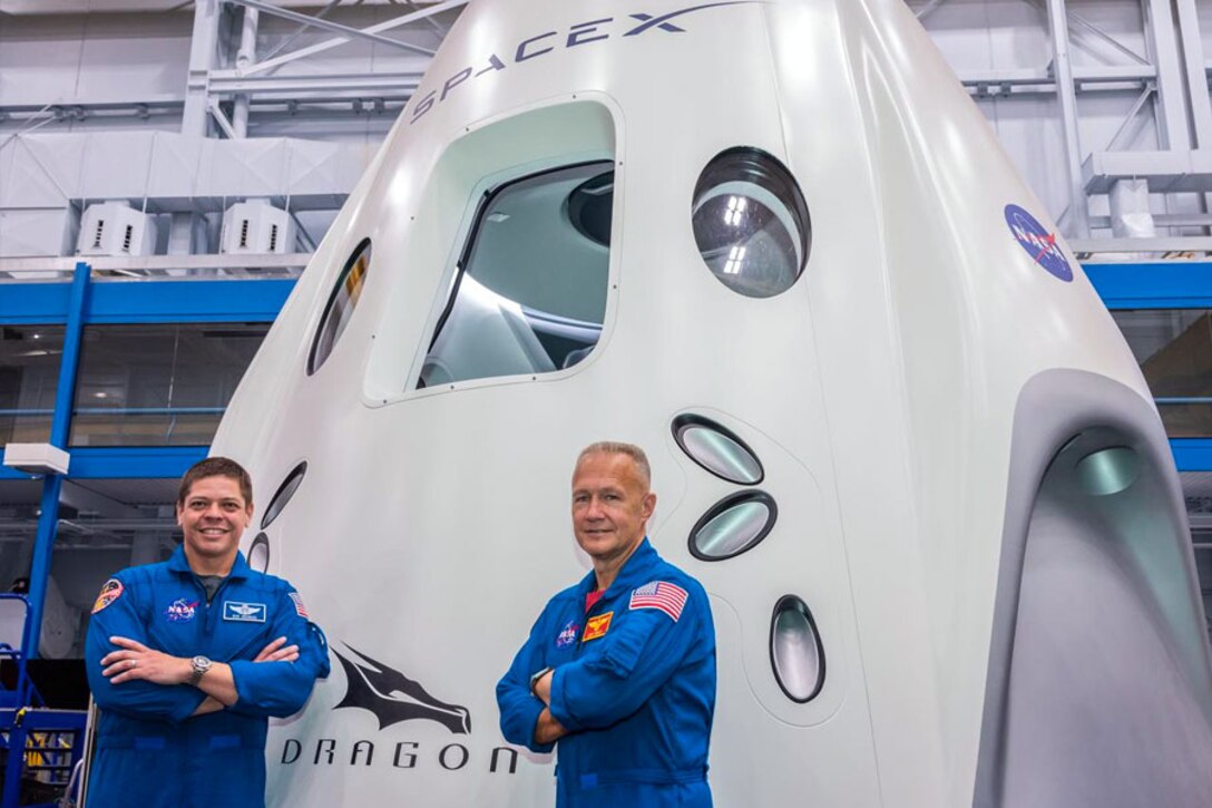 KENNEDY SPACE CENTER, Fla. – NASA astronauts Bob Behnken, Col., U.S. Air Force, left, and Doug Hurley, Col., U.S. Marine Corps, Ret., right, pose in front of SpaceX’s Dragon Crew spacecraft. During a brief shared with 50th Wing Staff Agencies Schriever Airmen on April 17, Soichi Noguchi, Japan Aerospace Exploration Agency astronaut, highlighted both astronauts will be part of mission Demo-2, the first manned launch of a spacecraft since the termination of the Space Shuttle Program in 2011, scheduled for May 27, 2020. (SpaceX courtesy photo)