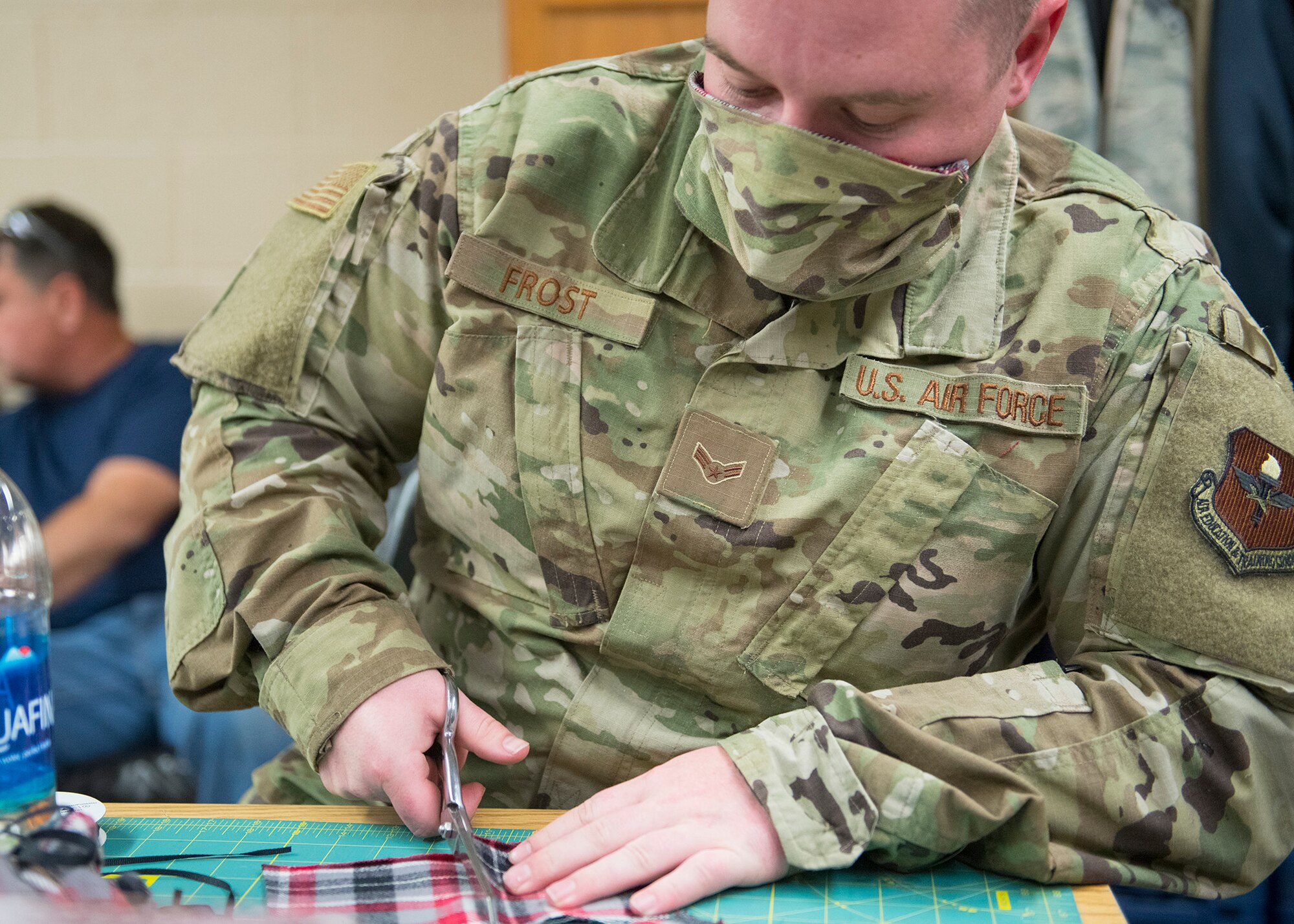 Airman 1st Class Taylor Frost, 56th Equipment Maintenance Squadron aircraft metals technology journeyman, cuts materials for a face mask April, 9, 2020, at Luke Air Force Base, Ariz.