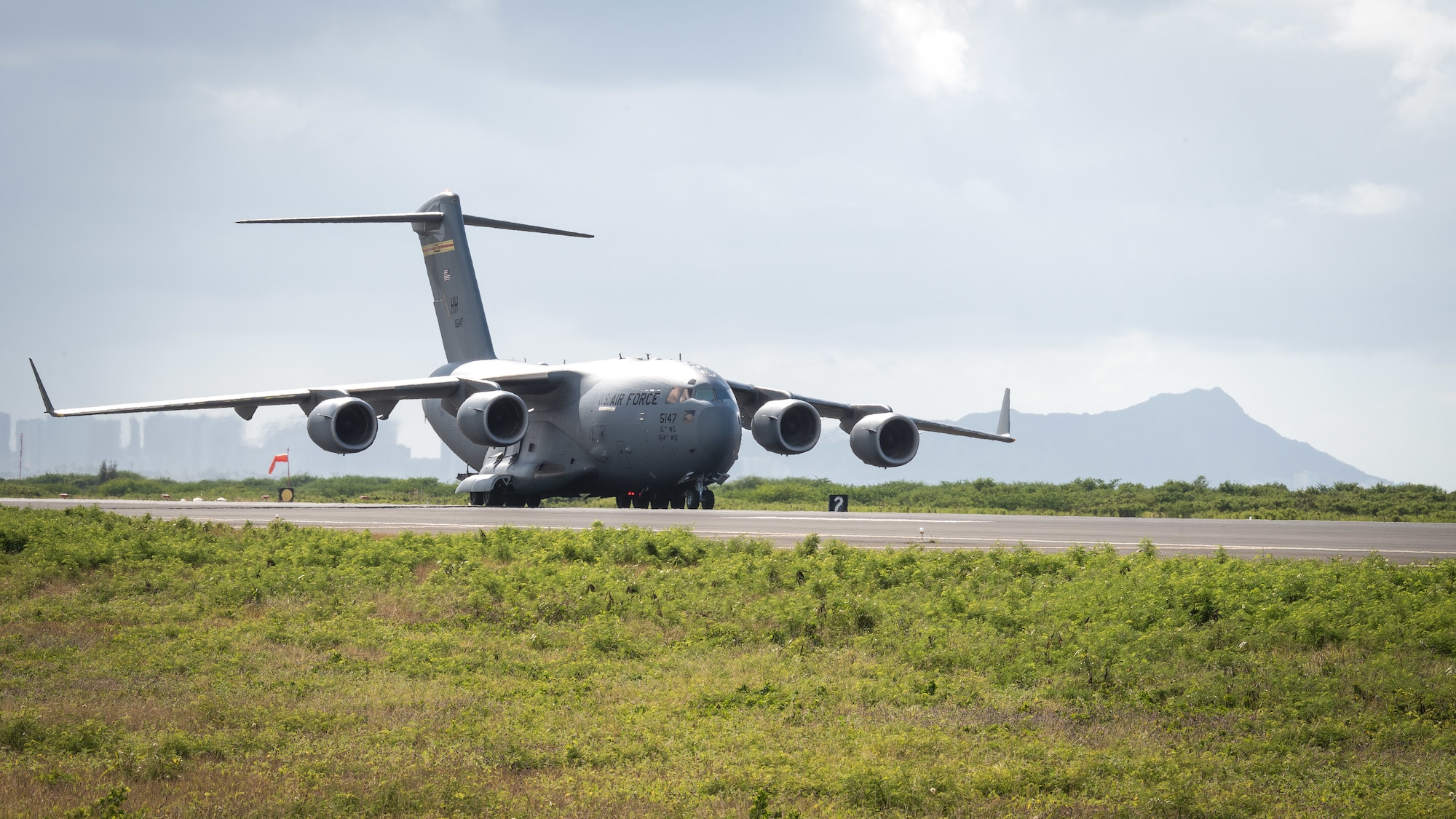 A U.S. Air Force C-17 Globemaster III taxis on the runway during a routine training schedule April 21, 2020, at Honolulu International Airport, Hawaii. Given the low traffic at the airport due to COVID-19 mitigation efforts, the active-duty 15th Wing and the Hawaii Air National Guard’s 154th Wing seized an opportunity to document the operation which showcases readiness and their unique Total Force Integration construct. The units of Team Hickam work together seamlessly to deliver combat airpower, tanker fuel, and humanitarian support and disaster relief across the Indo-Pacific. (U.S. Air National Guard photo by Senior Airman John Linzmeier)
