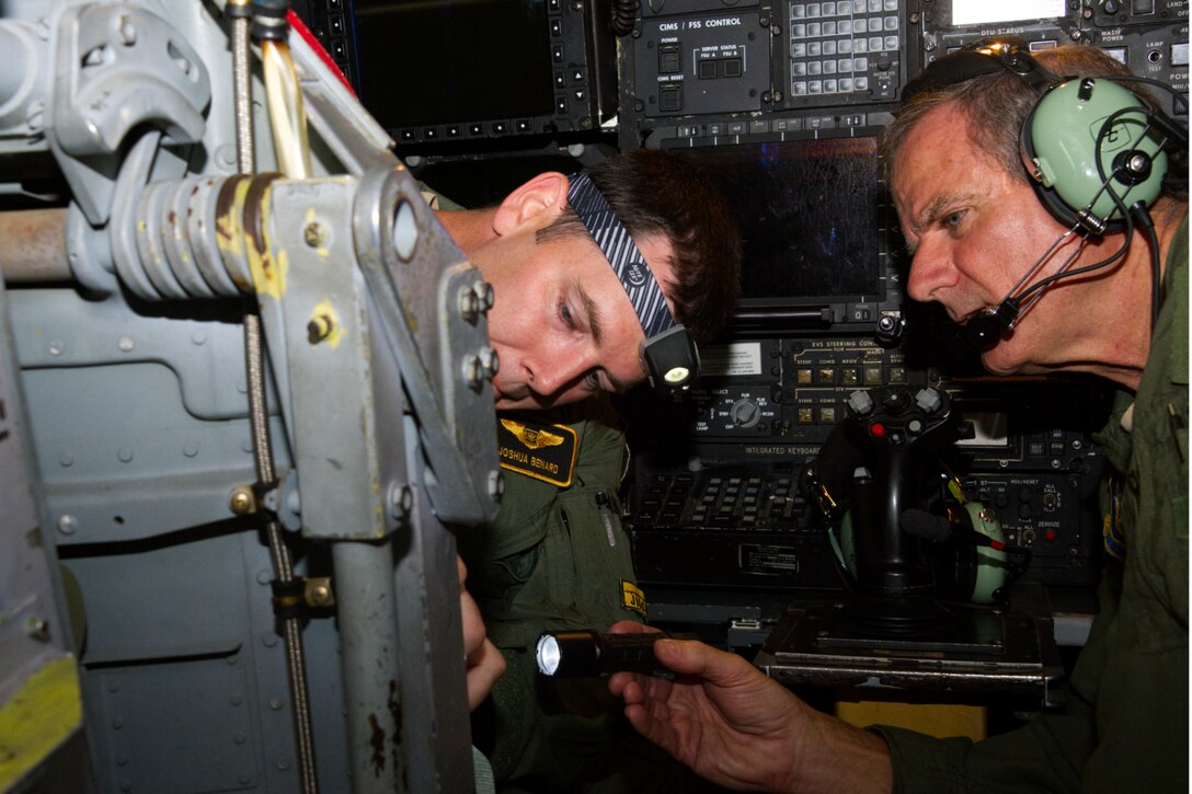 Photo of instructor and student looking at ejection seat.