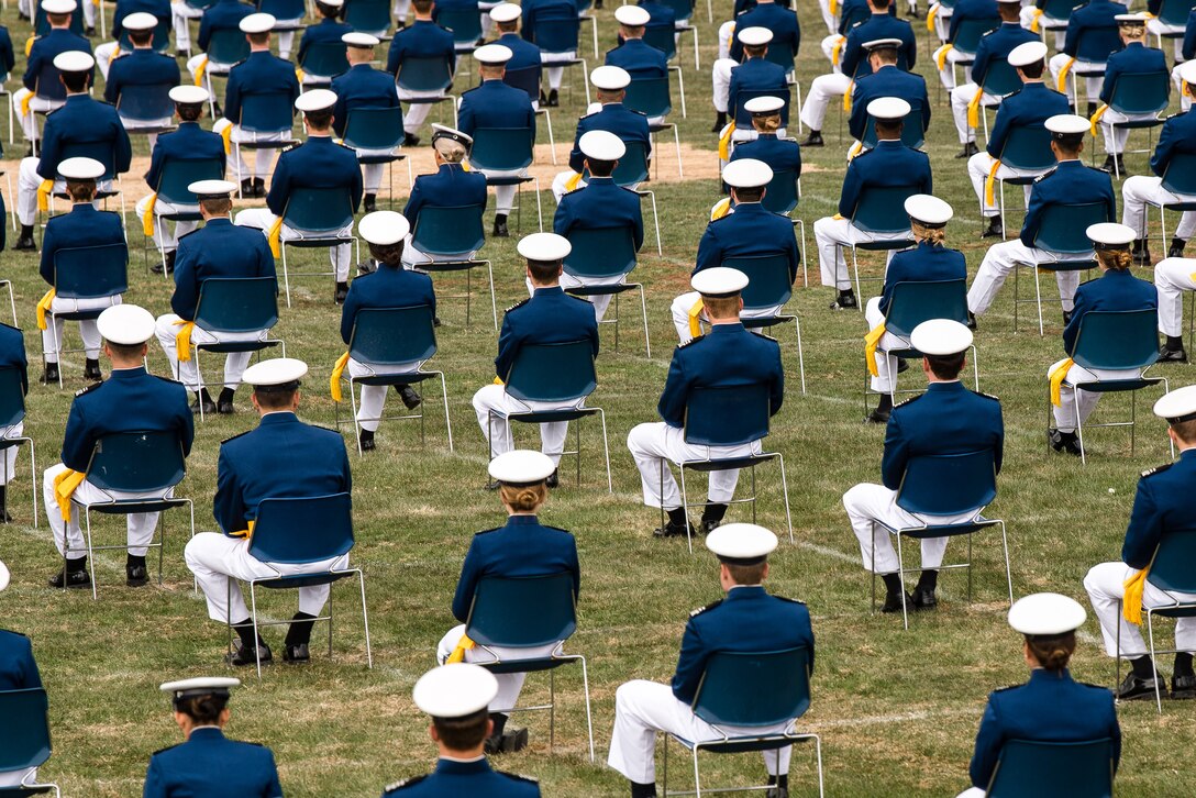 Cadets in dress uniform and cap, sit in lawn chairs spaced 6 feet in each direction.