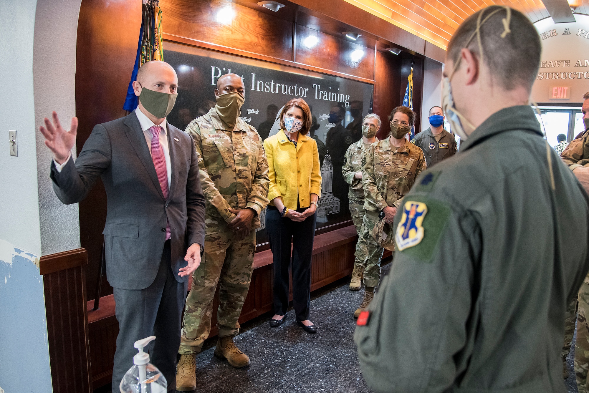 individuals stand in a flying training squadron hallway