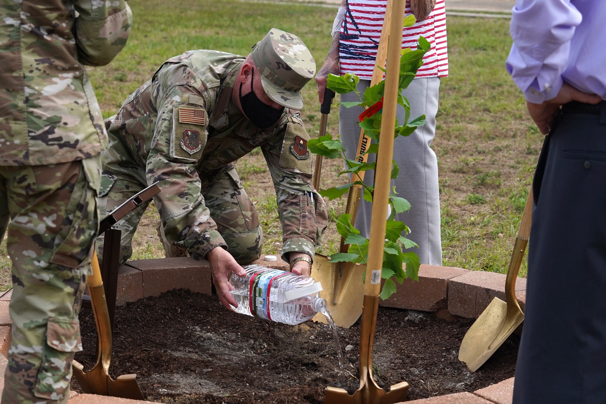 U.S. Air Force Chief Master Sgt. David Pizzuto, 81st Training Wing command chief, waters a tree during a tree-planting ceremony at Keesler Air Force Base, Mississippi, April 22, 2020. The tree was grown from a generation of seeds that flew with astronaut Col. Stuart A. Roosa as an experiment on mission Apollo 14. The tree was planted on Earth Day as a tribute to Apollo 14, Roosa, and human ingenuity. (U.S. Air Force photo by Airman 1st Class Seth Haddix)