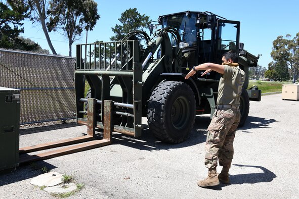 Senior Airman Nicholette Alonge and Airman 1st Class Chance Pickell, 30th Logistics Readiness Squadron ground transportation operators, move containers of cots April 22, 2020, at Vandenberg Air Force Base, Calif.