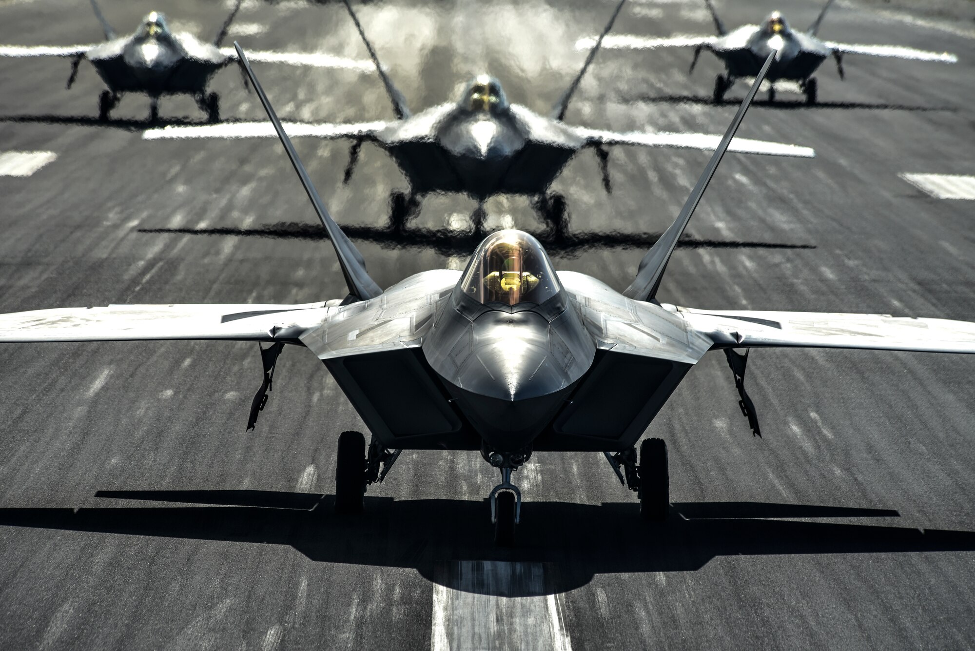 Eight U.S. Air Force F-22 Raptors, a KC-135 Stratotanker and a C-17 Globemaster III taxi on the runway during a routine training schedule April 21, 2020, at Honolulu International Airport, Hawaii. Given the low traffic at the airport due to COVID-19 mitigation efforts, the active-duty 15th Wing and the Hawaii Air National Guard’s 154th Wing seized an opportunity to document the operation which showcases readiness and their unique Total Force Integration construct. The units of Team Hickam work together seamlessly to deliver combat airpower, tanker fuel, and humanitarian support and disaster relief across the Indo-Pacific. (U.S. Air Force photo by Tech. Sgt. Anthony Nelson Jr.)