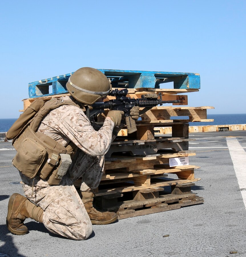 200414-M-MV109-1015 U.S. 5TH FLEET AREA OF OPERATIONS (April 14, 2020) Lance Cpl. Joseph Fischer, field artillery cannoneer, assigned to Fox Battery, Battalion Landing Team 2/8, 26th Marine Expeditionary Unit (MEU), fires an M4 carbine from the kneeling during a live-fire training range aboard the amphibious transport dock USS New York (LPD 21) April 14, 2020. New York, with embarked 26th MEU, is deployed to the U.S. 5th Fleet area of operations in support of naval operations to ensure maritime stability and security in the Central Region, connecting the Mediterranean and Pacific through the Western Indian Ocean and three strategic choke points. (Marine Corps photo by Staff Sgt. Patricia A. Morris)