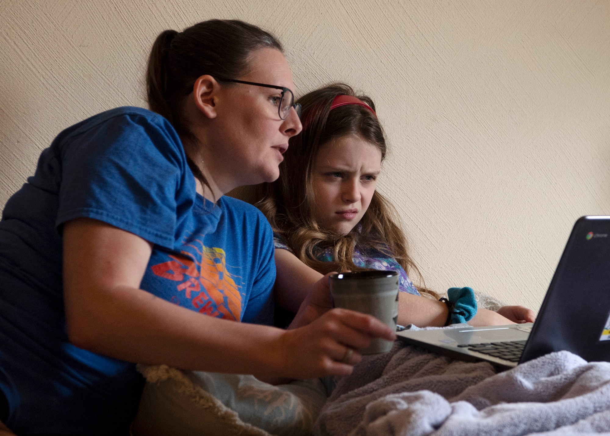 Beth and Bailey, wife and daughter of U.S. Army Sgt. 1st Class Cody Camp, U.S. Army Recruiting Command senior guidance counselor, read over a classwork assignment at their home in Kaiserslautern, Germany, April 14, 2020.