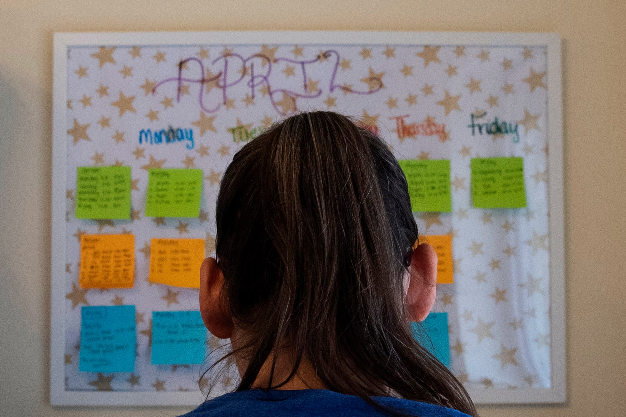 Beth, wife of U.S. Army Sgt. 1st Class Cody Camp, U.S. Army Recruiting Command senior guidance counselor, reads a calendar of her kids’ weekly class schedule in their home in Kaiserslautern, Germany, April 13, 2020.