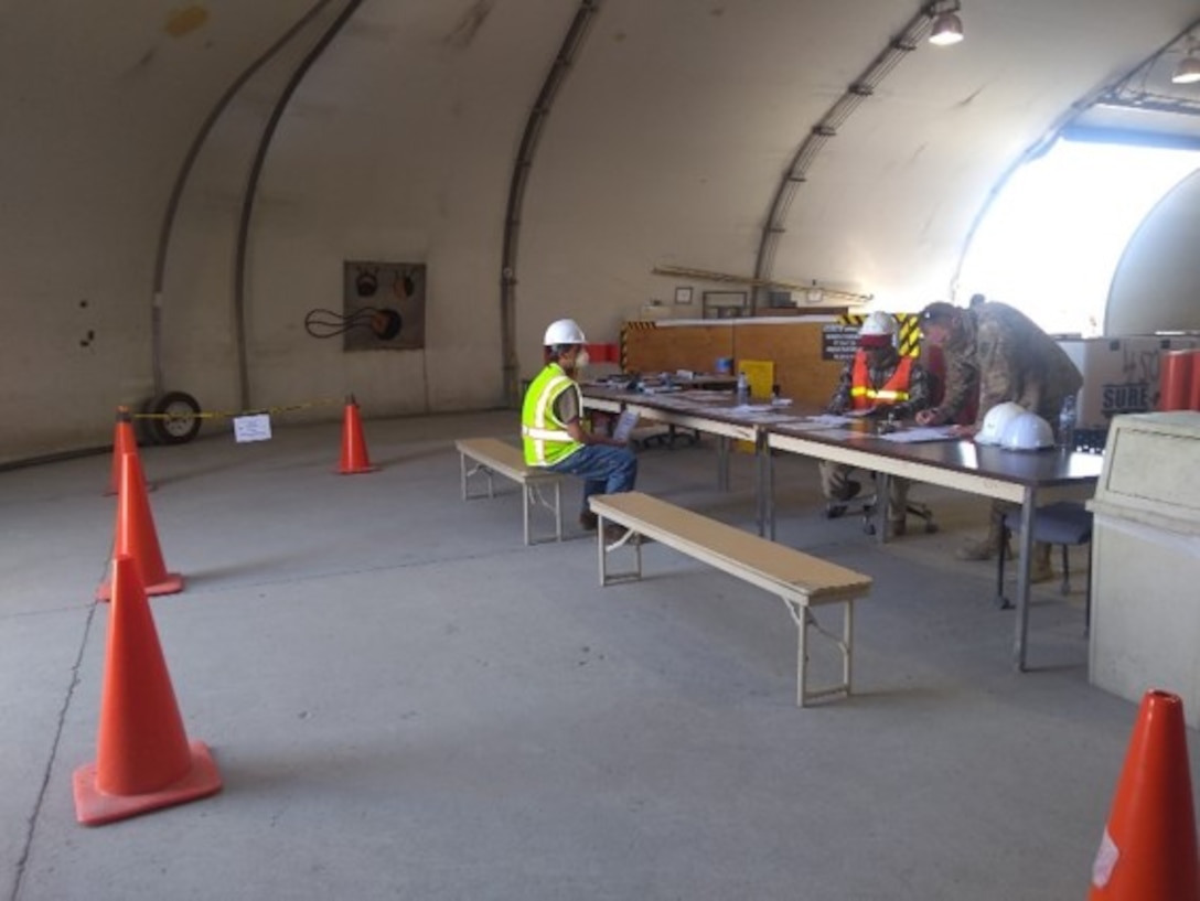 Employees at Bagram Airfield use a large, open bay to maintain social distancing as they receive and sort excess property.