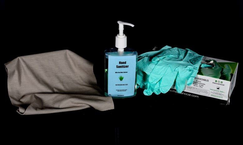A bottle of hand sanitizer, gloves and a face covering sit on a table at Aviano Air Base, Italy, April 23, 2020. The 31st Contracting Squadron made a contract with a local Italian vendor in order to quickly distribute face coverings to the base. (U.S. Air Force photo by Airman Thomas S. Keisler IV)