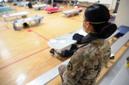 U.S. Army Spc. Courtney Casale of the California Army National Guard’s 250th Intelligence Battalion provides an extra set of eyes on residents' possessions at the Silverado Community Center temporary homeless shelter in Long Beach, California, April 16, 2020. Cal Guard Soldiers are helping staff two temporary shelters set up as part of the city’s COVID-19 response.