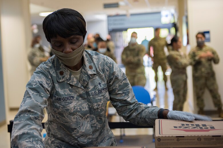 Major Michelle Law-Gordon, 628th Air Base Wing senior installation chaplain, prepares to pass out food at the 628th Medical Group at Joint Base Charleston, S.C. April 22, 2020. JB Charleston chaplains passed out pizza and sandwiches to raise morale and thank Medical Group personnel for all their hard work during the COVID-19 pandemic. The chaplains wore masks and gloves to protect the Airmen they handed food to.