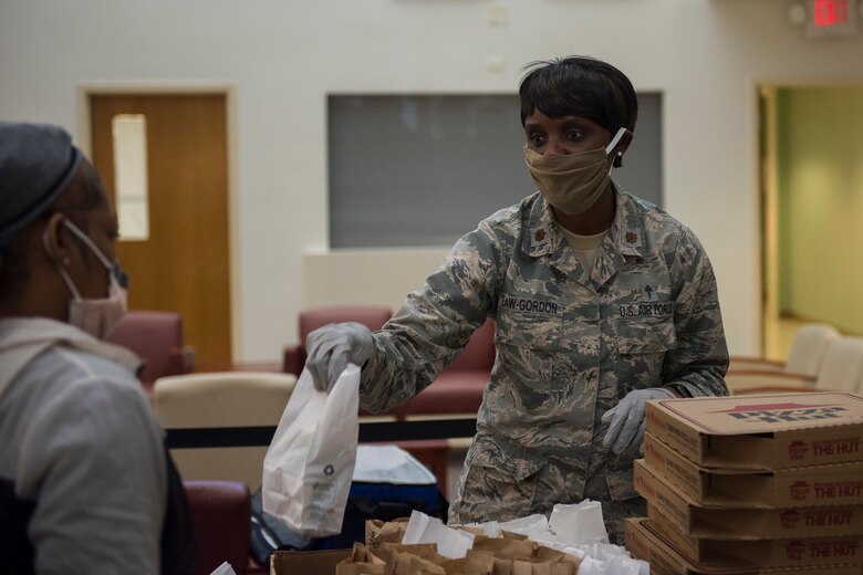 Major Michelle Law-Gordon, 628th Air Base Wing senior installation chaplain, passes out food at the 628th Medical Group at Joint Base Charleston, S.C. April 22, 2020. JB Charleston chaplains passed out pizza and sandwiches to raise morale and thank Medical Group personnel for all their hard work during the COVID-19 pandemic. The chaplains wore masks and gloves to protect the Airmen they handed food to.