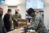 Major Michelle Law-Gordon, 628th Air Base Wing senior installation chaplain, passes out food at the 628th Medical Group at Joint Base Charleston, S.C. April 22, 2020. JB Charleston chaplains passed out pizza and sandwiches to raise morale and thank Medical Group personnel for all their hard work during the COVID-19 pandemic. The chaplains wore masks and gloves to protect the Airmen they handed food to.