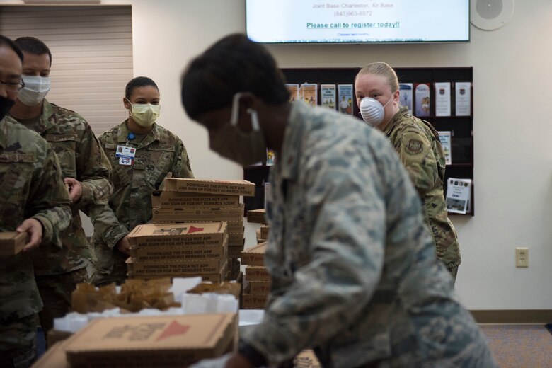 Major Michelle Law-Gordon, 628th Air Base Wing senior installation chaplain, and Master Sgt. Jennifer Deprinzio, 628th Air Base Wing superintendent of religious affairs, pass out food at the 628th Medical Group at Joint Base Charleston, S.C. April 22, 2020. JB Charleston chaplains passed out pizza and sandwiches to raise morale and thank Medical Group personnel for all their hard work during the COVID-19 pandemic. The chaplains wore masks and gloves to protect the Airmen they handed food to.