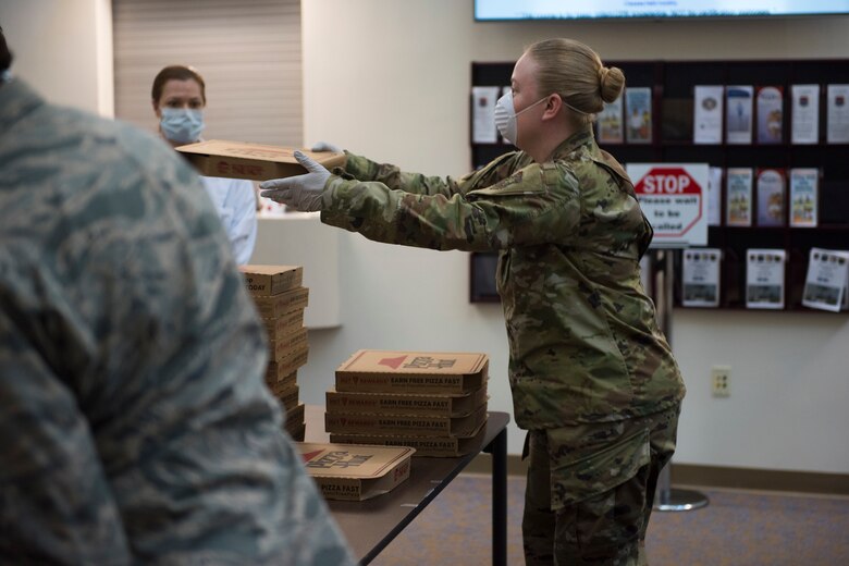 Master Sgt. Jennifer Deprinzio, 628th Air Base Wing superintendent of religious affairs, passes out food at the 628th Medical Group at Joint Base Charleston, S.C. April 22, 2020. JB Charleston chaplains passed out pizza and sandwiches to raise morale and thank Medical Group personnel for all their hard work during the COVID-19 pandemic. The chaplains wore masks and gloves to protect the Airmen they handed food to.