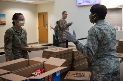 Major Michelle Law-Gordon, 628th Air Base Wing senior installation chaplain, and Lt. Col. Christine Smetana, the 628th Operational Medical Readiness Squadron Commander, talk about the morale event happening at the 628th Medical Group at Joint Base Charleston, S.C. April 22, 2020. JB Charleston chaplains passed out pizza and sandwiches to raise morale and thank Medical Group personnel for all their hard work during the COVID-19 pandemic. The chaplains wore masks and gloves to protect the Airmen they handed food to.