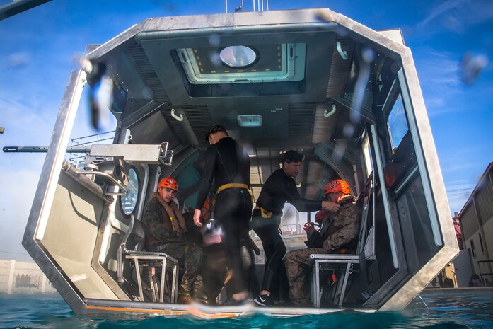Instructors from the Infantry Immersion Trainer facility inspect U.S. Marines before they are submerged in the Modular Amphibious Egress Trainer during underwater egress training at Marine Corps Base Camp Pendleton, California, March 19.