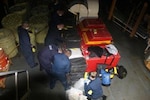 A Coast Guard boat crew recovers bales of cocaine.