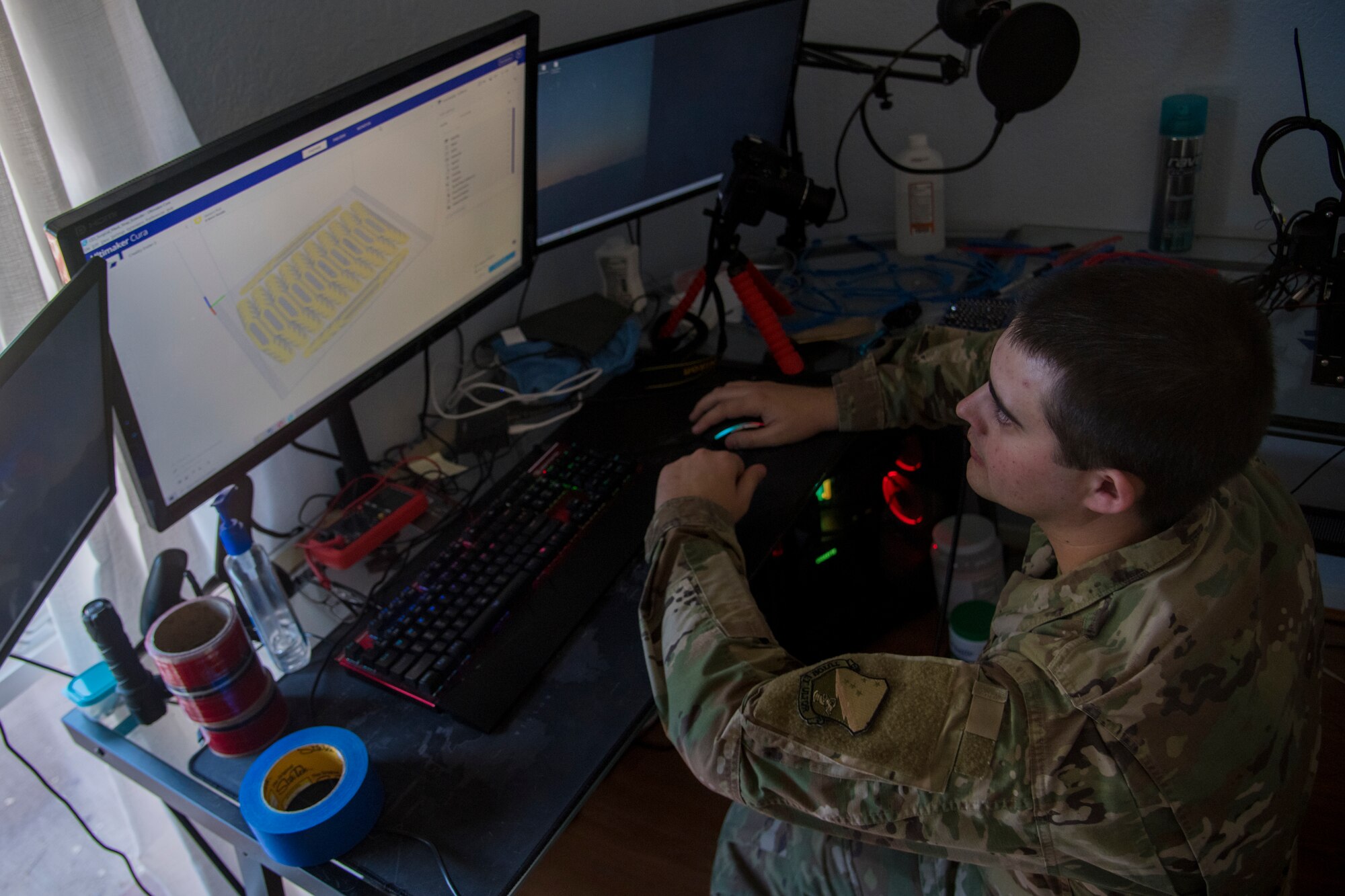 Staff Sgt. Jakob Powers, 54th Operations Squadron air traffic controller, works on his 3-D face-covering extender model before printing the device at his residence in Alamogordo, N.M., on April 16, 2020. During his downtime, Powers print 3-D face-covering extenders and face-shield frames to provide safety and comfort to essential personnel such as hospital workers, firefighters and police officers. (U.S. Air Force photo by Senior Airman Collette Brooks)