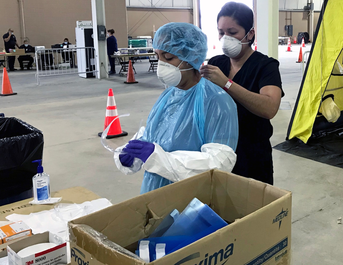 Capt. Gabriella Torres assists Capt. Denise Rodriguez with securing her personal protective equipment.