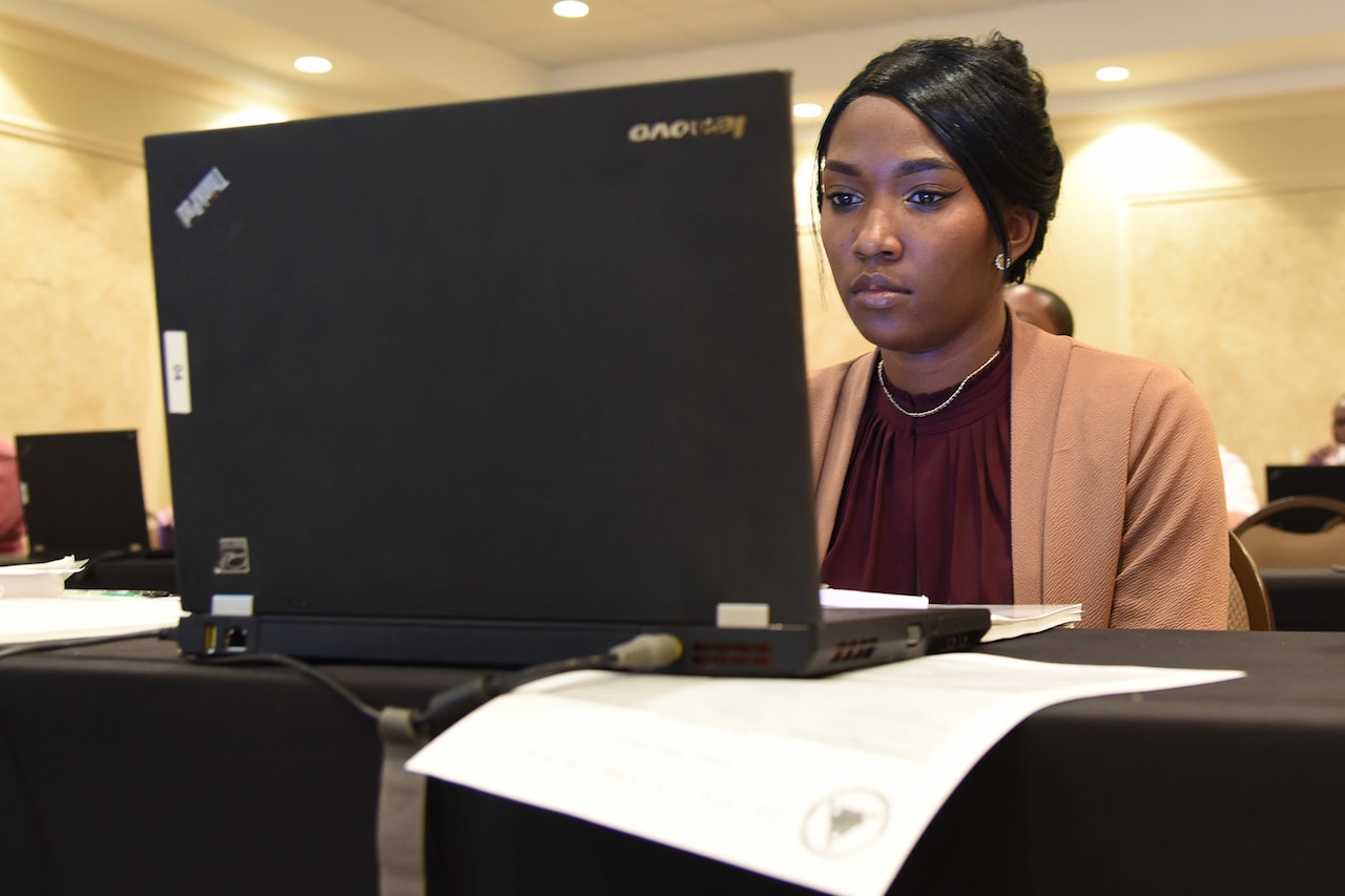 A woman looks at the screen of a laptop computer.