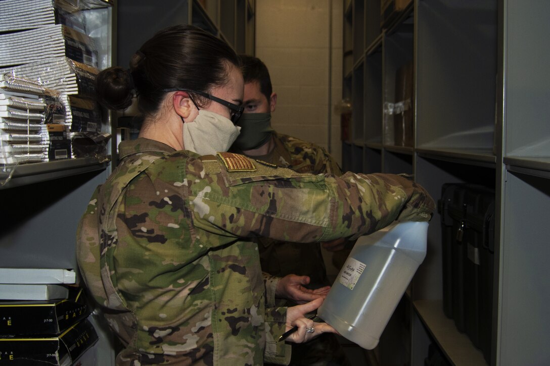 Senior Airman Caitlyn Truax, 11th Security Support Squadron supply technician, examines a gallon of hand sanitizer on Joint Base Andrews, Md., April 20, 2020. The hand sanitizer is distributed to different units as needed. In total, there are 30 gallons of hand sanitizer.