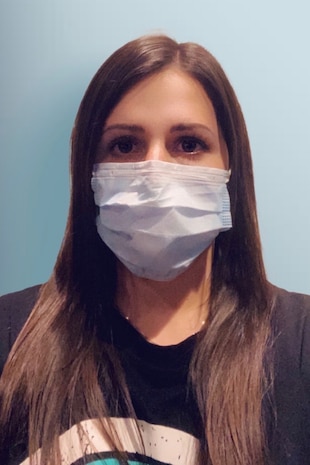 A portrait of Ashley Jones wearing a face covering.