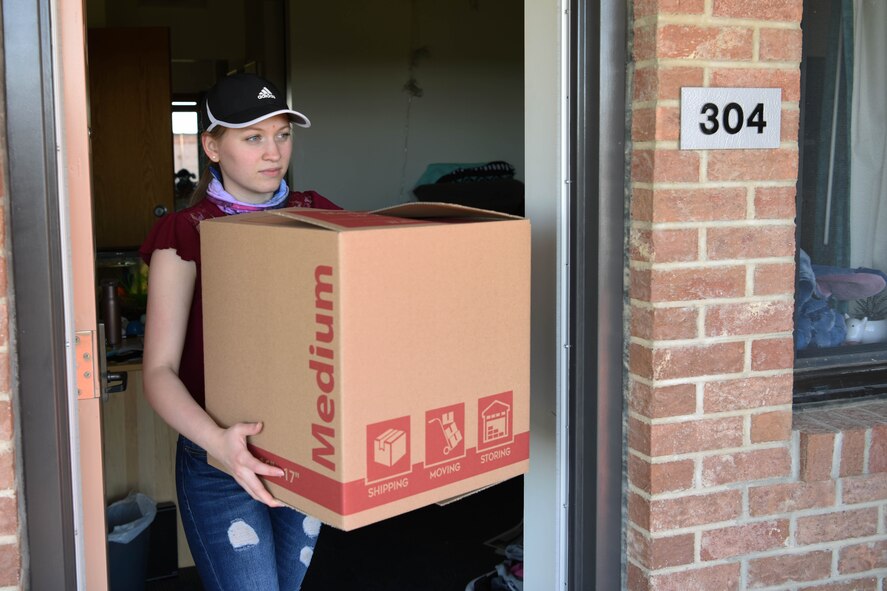 Airman 1st Class Billie Fisler, Distributed Mission Operations Center – Space administrator, carries a box to her car at Peterson Air Force Base, Colorado, April 24, 2020. Fisler is currently moving out of the dormitories due to occupancy exceeding 95%. (U.S. Air Force photo by Airman 1st Class Jonathan Whitely)