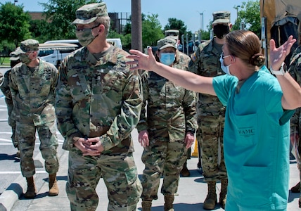 briefs Gen. James McConville, Chief of Staff of the Army, on COVID-19 screening operations at BAMC at  Joint Base San Antonio-Fort Sam Houston April 23. McConville visited BAMC during his tour of Joint Base San Antonio.