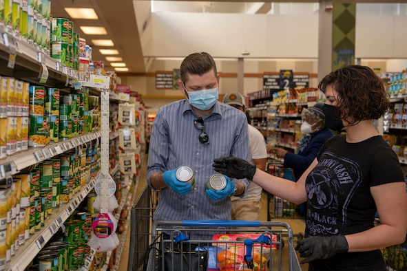 John Christ, left, husband of U.S. Air Force Senior Airman Nichole Krinberg, right, 60th Aerial Port Squadron air transportation journeyman, shops for vegetables April 16, 2020, with Krinberg, inside the commissary at Travis Air Force Base, California. Since the coronavirus pandemic, some food and household goods such as toilet paper and paper towels have become increasingly scarce. (U.S. Air Force photo by Tech. Sgt. James Hodgman)