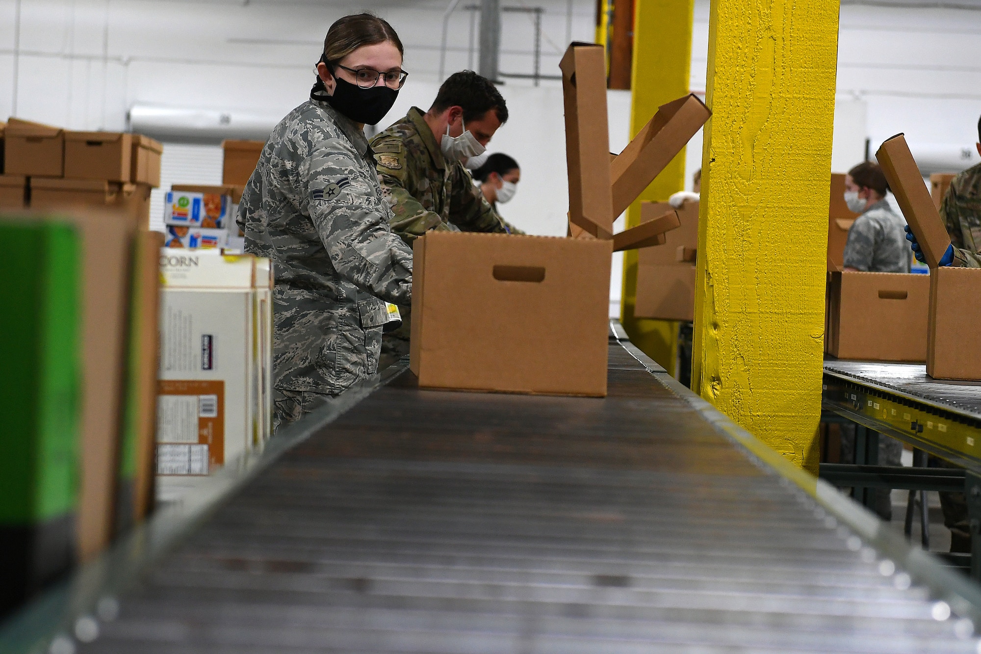Washington Air National Guard Airman 1st Class Grace Tesch, 141st Medical Group, packs food boxes at the Food Lifeline Covid Response warehouse in Seattle April 23, 2020. More than 250 Air and Army National Guard members are assigned to the warehouse to prepare, on average, 268 boxes an hour.
