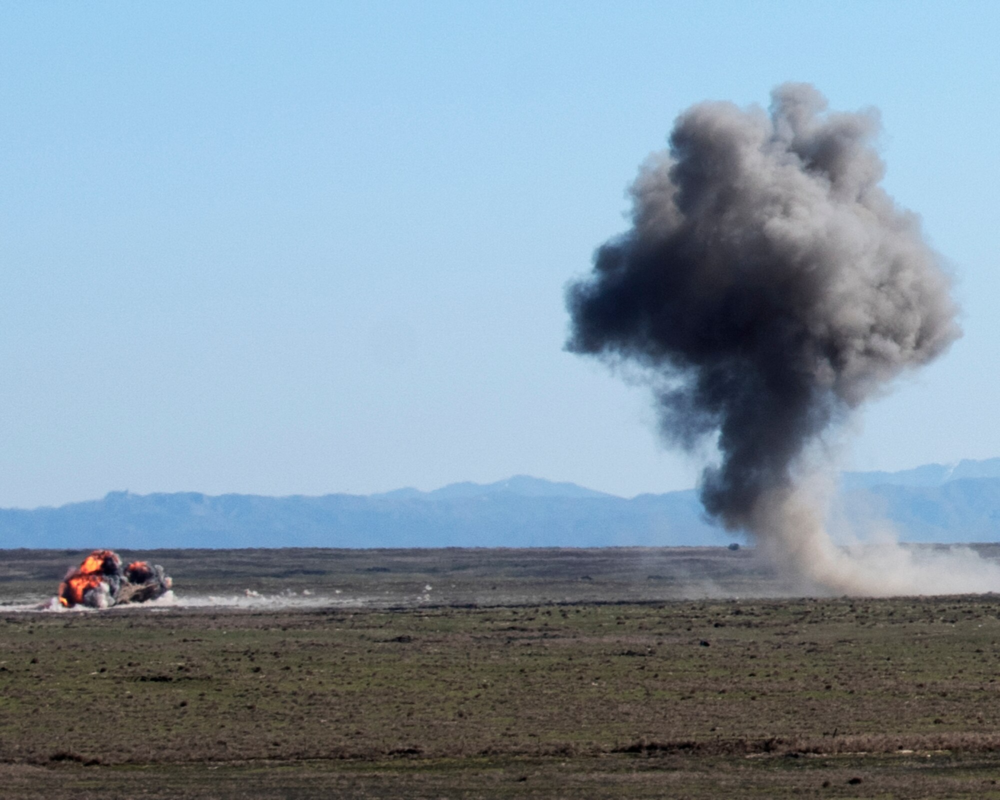 Explosions from two Mark 82 bombs ignite, April 17, 2020, at Orchard Combat Training Center, Idaho. Two F-15E Strike Eagles dropped live bombs while working directly with the Idaho Air National Guard to improve joint training capabilities. (U.S. Air Force photo by Airman Natalie Rubenak).