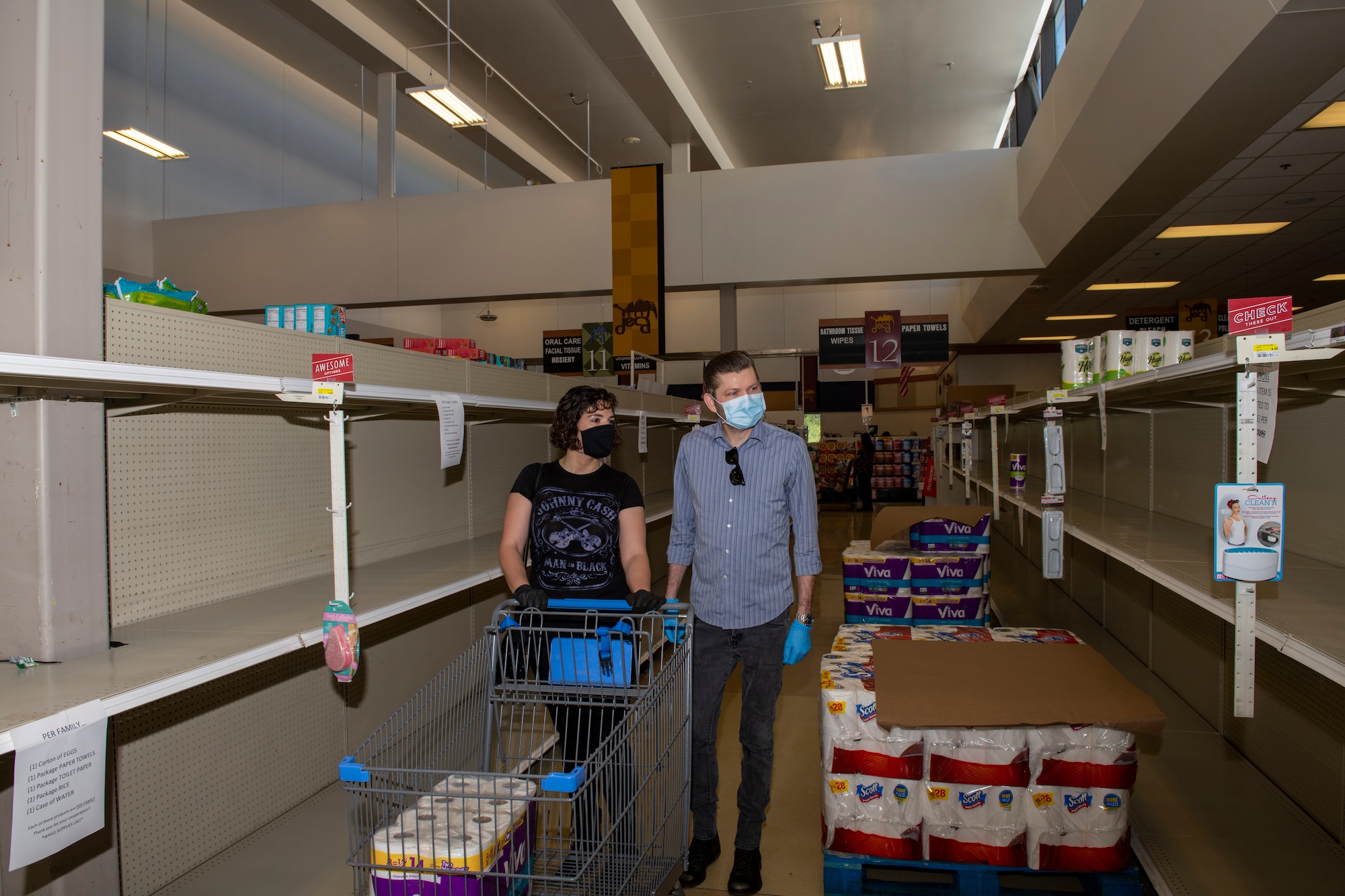 U.S. Air Force Senior Airman Nichole Krinberg, left, 60th Aerial Port Squadron air transportation journeyman, shops for paper towels with her husband, John Christ,  April 16, 2020, inside the commissary at Travis Air Force Base, California. Since the coronavirus pandemic, household goods such as toilet paper and paper towels have become increasingly scarce. (U.S. Air Force photo by Tech. Sgt. James Hodgman)