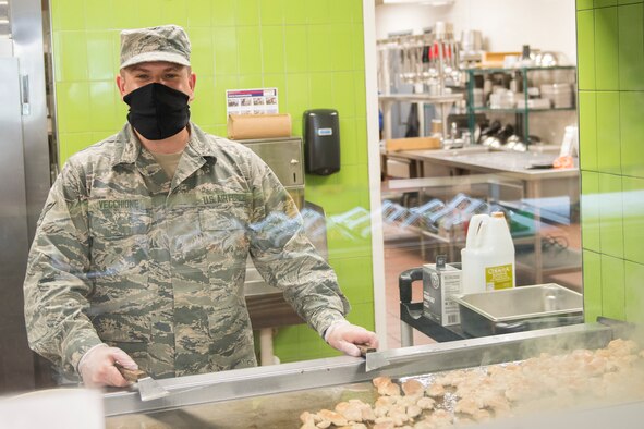 Airman 1st Class David Vecchione, a food service journeyman assigned to the 628th Force Support Squadron, poses for a photo at the Gaylor Dining Facility at Joint Base Charleston, S.C., April 22, 2020. Dining facility personnel are cleaning more often, wearing masks and gloves and practicing physical distancing in order to protect themselves and customers. The DFAC is currently open for carry out only.