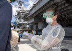 U.S. Navy Cmdr. Brianna Rupp, a preventative medicine physician from the Navy and Marine Corps Public Health Center, takes a survey from a U.S. Sailor, assigned to the aircraft carrier USS Theodore Roosevelt (CVN 71), as part of a public health outbreak investigation April 22, 2020. This specific outbreak investigation is expected to provide a better-informed understanding of this outbreak and guide decision making for the crew. Upon arriving in Guam March 27, Theodore Roosevelt established an Emergency Command Center, initiated a roving and deep cleaning team, and continually educated the crew on social distancing and proper protective procedures and behaviors, to assist the crew in mitigating and controlling the spread of COVID. Theodore Roosevelt is in Guam for a scheduled port visit for resupply and crew rest during their scheduled deployment to the Indo-Pacific.