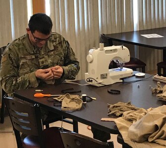 Maj. Robert Winston of the 224th Air Defense Group threads a needle during sewing "operations" at the Eastern Air Defense Sector in Rome.