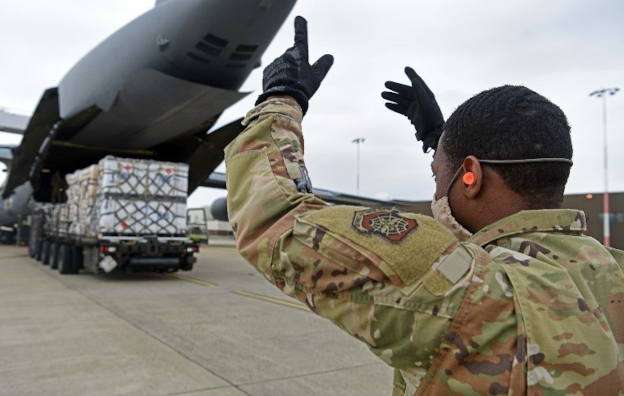 Airman directs K-loader unloading C-5 Super Galaxy.